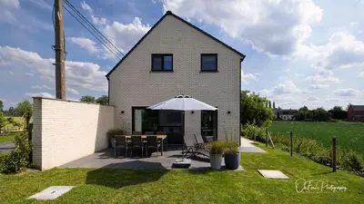 a house with an umbrella and a table and chairs at Vakantiehuis Paula in Watervliet