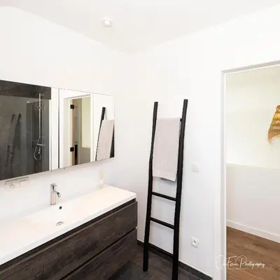 a bathroom with a sink and a ladder next to a mirror at Vakantiehuis Paula in Watervliet