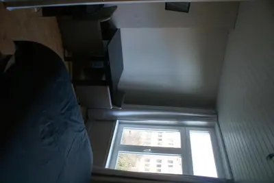 an attic room with a window and a staircase at Guest House Feliz in Leuven