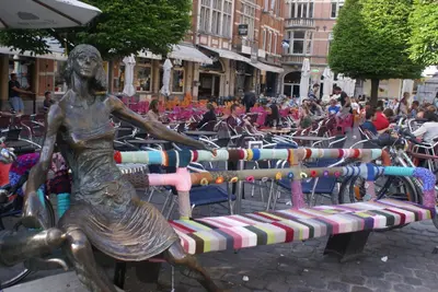 a statue of a woman sitting on a bench at Guest House Feliz in Leuven