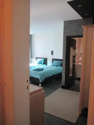 a bedroom with two beds and a mirror at Guest House Feliz in Leuven