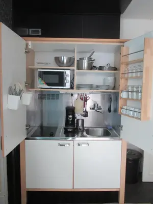 a small kitchen with a sink and a microwave at Guest House Feliz in Leuven