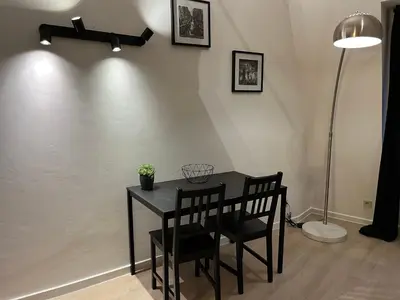 a dining room table with two chairs and a lamp at Brussels center flat in Brussels