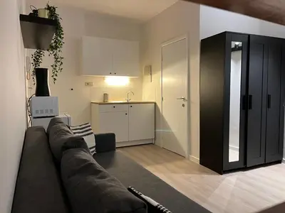 a living room with a couch and a kitchen at Brussels center flat in Brussels