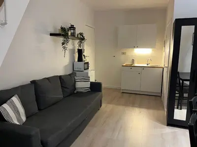 a living room with a couch and a kitchen at Brussels center flat in Brussels