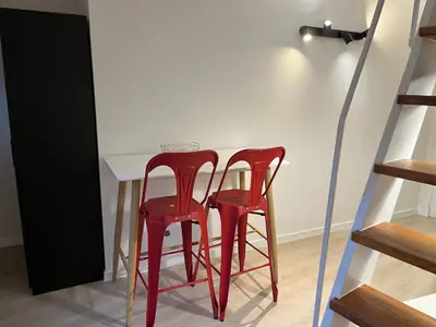 two red stools sitting next to a table at Brussels center flat in Brussels