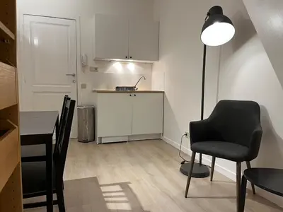 a living room with a table and a chair and a lamp at Brussels center flat in Brussels