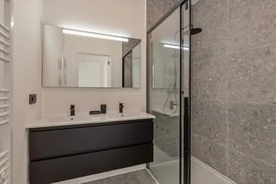 a bathroom with a sink and a glass shower at Märch - Mechelen Goat 21 in Mechelen