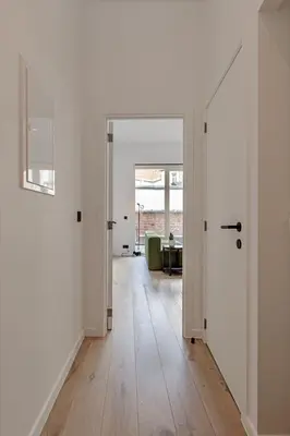 an empty hallway with white walls and wooden floors at Märch - Mechelen Goat 21 in Mechelen