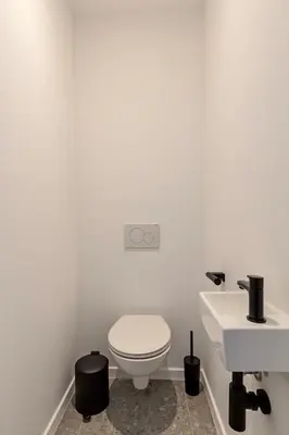 a white bathroom with a toilet and a sink at Märch - Mechelen Goat 21 in Mechelen