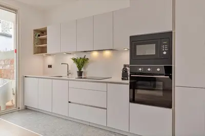 a kitchen with white cabinets and a microwave at Märch - Mechelen Goat 21 in Mechelen