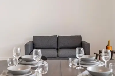 a living room with a couch and a table with wine glasses at Märch - Mechelen Goat 21 in Mechelen
