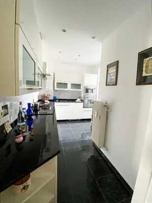 a kitchen with white cabinets and a black counter top at Elegance ,Space & Luxury in Brussels in Brussels