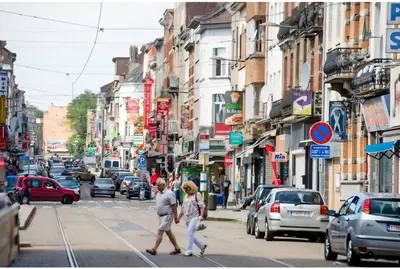 two people crossing a busy city street with cars at appartement douvres in Brussels