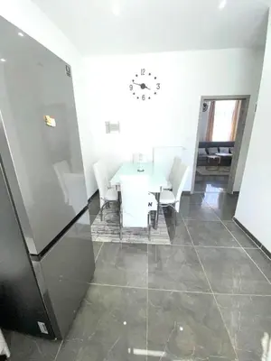 a room with a table and chairs and a clock on the wall at appartement douvres in Brussels