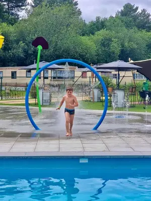 a young child is walking under a jump in a pool at Vakantiepark Breebos: Empty Lots for tents and mobile homes in Rijkevorsel