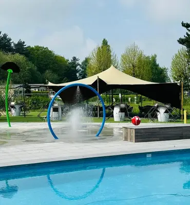 a pool with a fountain in front of a tent at Vakantiepark Breebos: Empty Lots for tents and mobile homes in Rijkevorsel