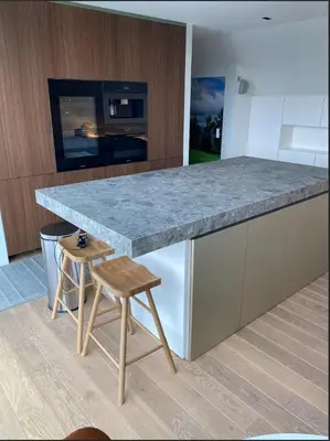 a kitchen with a granite counter top and a wooden stool at Business Accommodation Luxury Loft in Geel