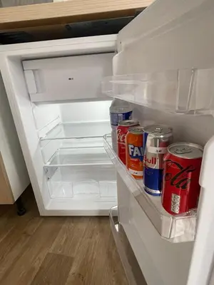 an open refrigerator with drinks and cans of soda at cantillonn in Brussels