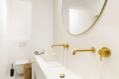 a white bathroom with a mirror and a sink at High-end 3BDR apartment @ city center in Antwerp
