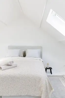 a white bedroom with a white bed and a lamp at High-end 3BDR apartment @ city center in Antwerp