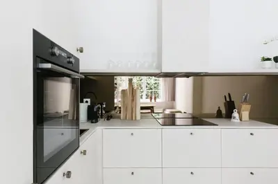 a kitchen with white cabinets and black appliances at High-end 3BDR apartment @ city center in Antwerp