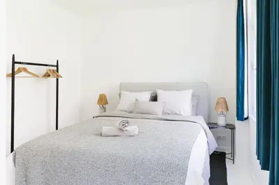 a white bedroom with a bed with a towel on it at High-end 3BDR apartment @ city center in Antwerp