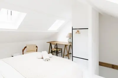 a white room with a bed and a table at High-end 3BDR apartment @ city center in Antwerp