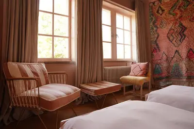 a hotel room with two beds and chairs and windows at Edville Home in Ghent