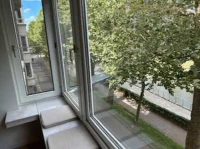 a window with a view of a tree at Ghent by the water in Ghent