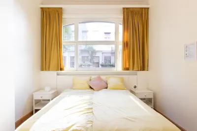 a bed in a room with a window at Pauline Loveling apartment with quiet garden and 2 bathrooms in Antwerp