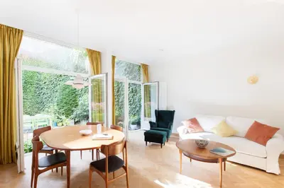 a living room with a white couch and a table at Pauline Loveling apartment with quiet garden and 2 bathrooms in Antwerp