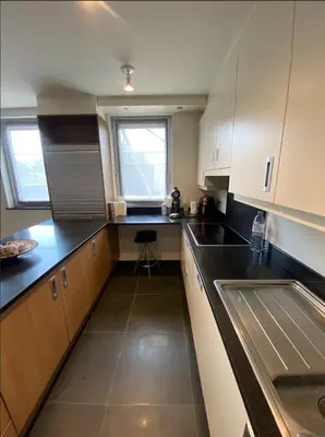 a kitchen with black counters and white cabinets and a sink at Business Accommodation Luxury XL Geel in Geel