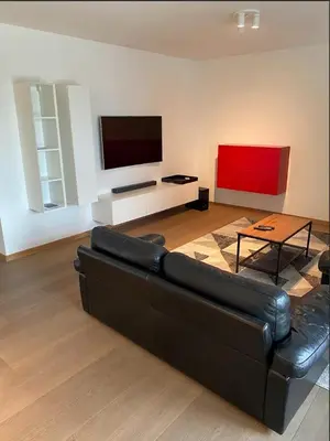 a living room with a black couch and a flat screen tv at Business Accommodation Luxury XL Geel in Geel