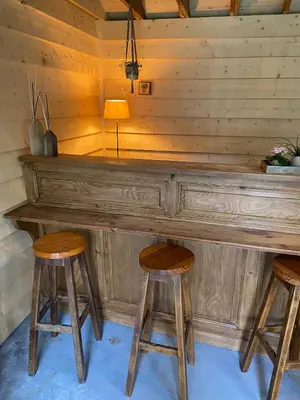 a wooden bar in a cabin with two stools at Maison Patisson in Kasterlee
