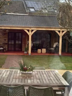 a wooden picnic table in front of a house at Maison Patisson in Kasterlee