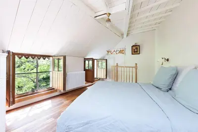 a bedroom with a large bed and a large window at Carriage House in quiet ecological garden in Antwerp