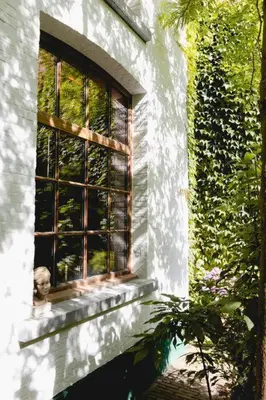 a window on the side of a building at Carriage House in quiet ecological garden in Antwerp