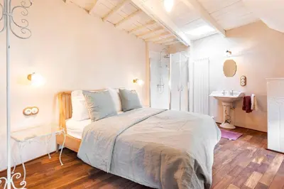 a bedroom with a large bed and a sink at Carriage House in quiet ecological garden in Antwerp