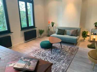 a living room with a couch and a table at Royal South - Apartment Antwerp with Parkview in Antwerp