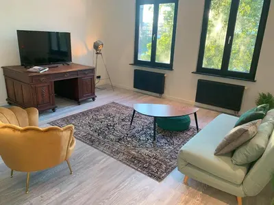 a living room with a couch and a table and a tv at Royal South - Apartment Antwerp with Parkview in Antwerp