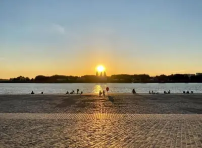 a sunset on a beach with a body of water at Royal South - Apartment Antwerp with Parkview in Antwerp