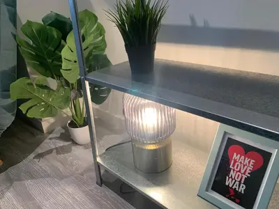 a light on a shelf with plants and a sign at Royal South - Apartment Antwerp with Parkview in Antwerp