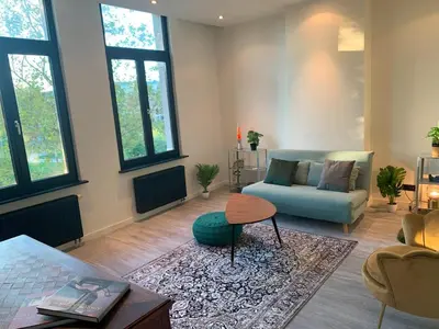 a living room with a couch and a table at Royal South - Apartment Antwerp with Parkview in Antwerp