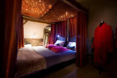 a bedroom with a large bed with red curtains at B&B Oase in Londerzeel