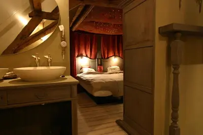 a bathroom with a sink and a bedroom with a bed at B&B Oase in Londerzeel