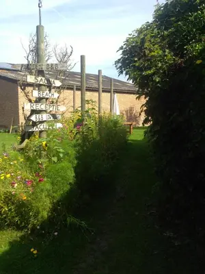 a garden with a sign in front of a building at B&B Oase in Londerzeel