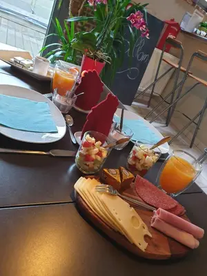 a table with a plate of cheese and other foods at B&B Oase in Londerzeel