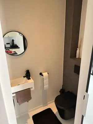 a bathroom with a black toilet and a mirror at Antwerp West Side, TERRACE in Zwijndrecht