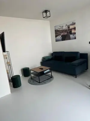 a living room with a blue couch and a coffee table at Antwerp West Side, TERRACE in Zwijndrecht